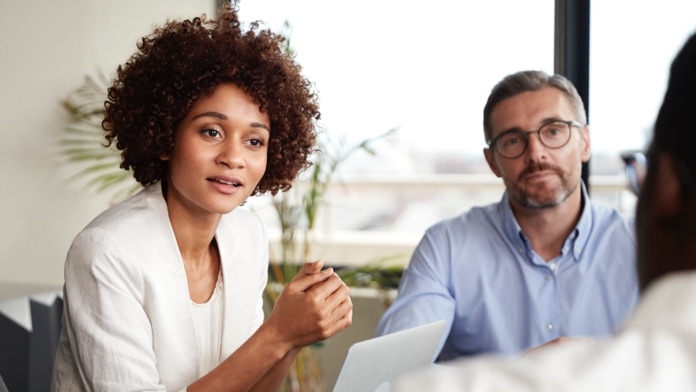 Businesswoman listening to colleagues at a business meeting