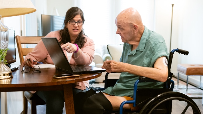 Caregiver and woman going through paperwork in a bedroom