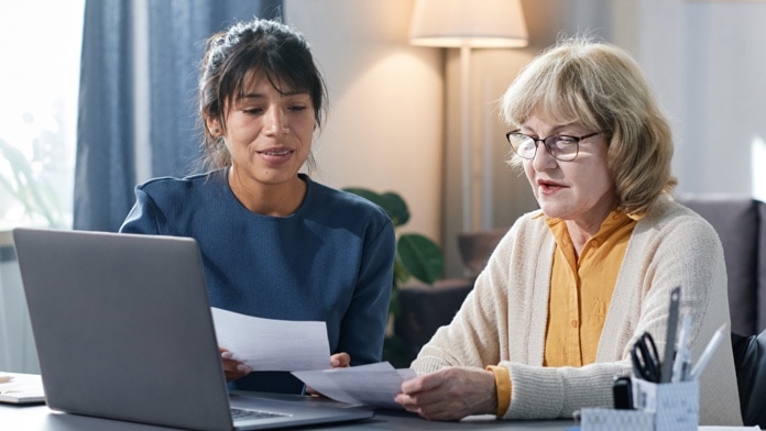 Senior woman reviewing some paperwork with a young adult woman